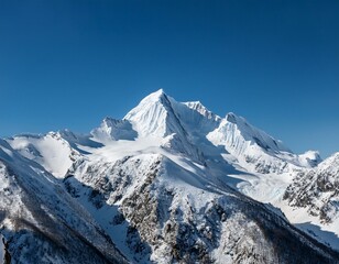Obraz premium Majestic Snowy Mountain Peaks: Towering snow-capped mountain peaks pierce a bright blue sky, showcasing the dramatic beauty and raw power of nature.