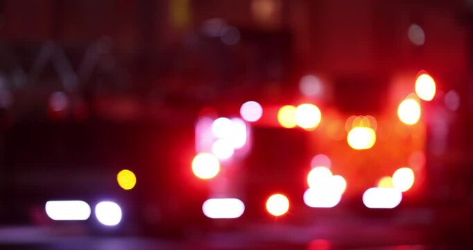 Abstracted blurred bokeh view of a fire engine responding to the scene of an emergency at night.