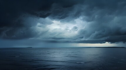 Obraz premium Dramatic gray clouds loom over a serene reflective ocean horizon in this moody atmospheric landscape The muted monochrome tones create a pensive contemplative mood