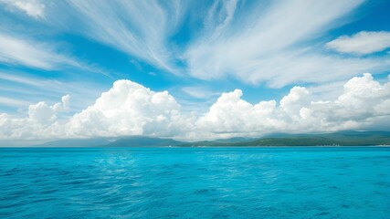 tropical beach with turquoise water and white clouds in the blue sky