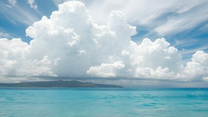tropical beach with turquoise water and white clouds in the blue sky
