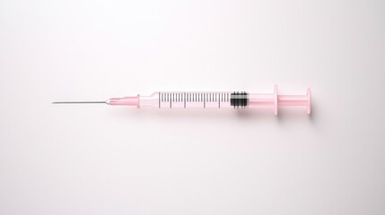 Fototapeta premium A close-up view of a pink syringe against a minimalist background, symbolizing healthcare and medical applications.