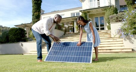 Setting up solar panel, father and daughter working together in front yard - Powered by Adobe