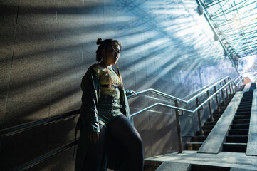 Portrait of a young Asian woman posing in the subway near the stairs. 
