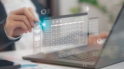 Businessman manages time for effective work. Calendar on the virtual screen interface. Highlight appointment reminders and meeting agenda on the calendar. Time management concept.