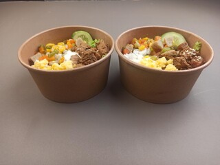 Rice box with meat side dishes, scrambled eggs, meatballs and sweet corn.
