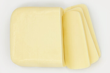 MOZZARELLA CHEESE BAR VIEW FROM TOP WITH SLICES ON PLATE ISOLATED ON WHITE BACKGROUND