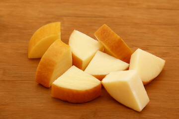 SMOKED PROVOLONE CHOPPED INTO SMALL PIECES ON THE WOODEN TABLE