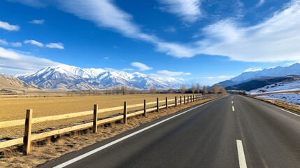 Scenic Mountain Roadtrip Through Majestic Snow-Capped Mountains and Golden Fields Under Bright Blue Sky in Beautiful Landscape