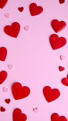 Valentine's Day background with red and pink heart-shaped decorations on a pink surface