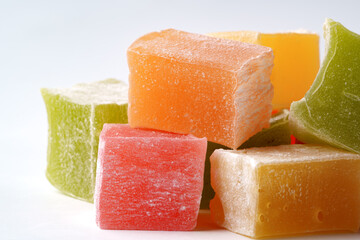 Colorful fruit-flavored jelly cubes attractively arranged on a white surface showcasing their vibrant hues