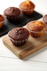 Assorted muffins on wooden board showcasing delicious baked goods for dessert or snacks