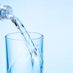 Crystal clear water being poured into a transparent glass, creating refreshing ripples and bubbles