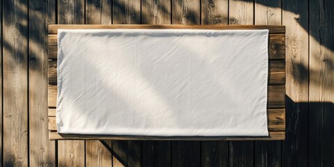 Aerial view of a rustic wooden table with a white tablecloth centered on it surrounded by warm wooden tones ample space for text display