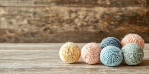 Colorful wool balls in pastel hues of yellow, pink, blue, and green arranged in a cluster on a rustic wooden table against a textured backdrop.