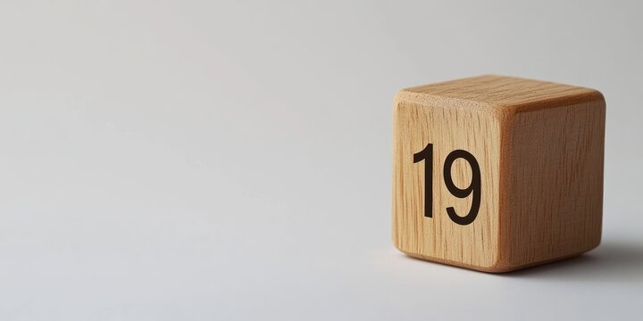 Wooden cube calendar showing the number 19 in bold black font on a light grey background, positioned to the right with empty space on the left