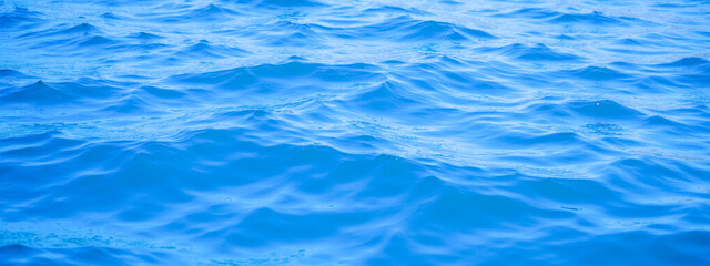 Fototapeta premium Peaceful blue ocean waves creating a calm and serene sea surface, perfect for natural backgrounds, marine textures, and tranquil aquatic scenery. Ideal for showcasing oceanic pattern