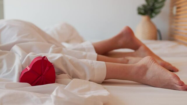 Female couple waking up in bed on valentine's day