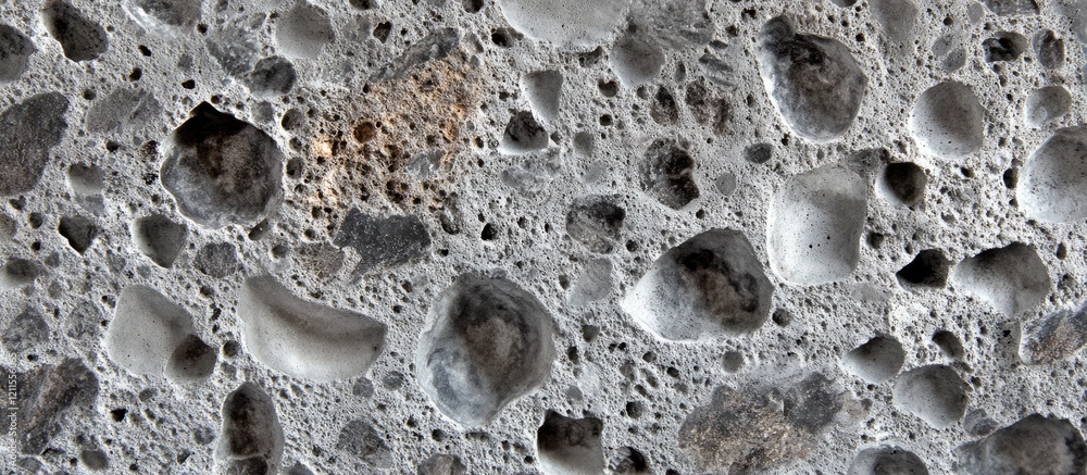Poster finely textured gray concrete surface with varying sizes of aggregate and air pockets showcasing uni