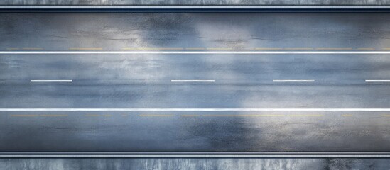 Aerial view of a wet asphalt road with white dashed lane markings and a textured blue-gray surface reflecting light and shadows.