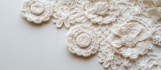 Obraz premium Delicate cream crochet motifs arranged artistically on a soft beige background highlighting intricate lace patterns and exceptional craftsmanship