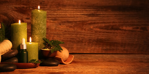 Beautiful spa composition with burning candles and fern leaves on dark wooden background