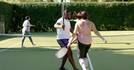 Playing tennis, Diverse Friends celebrating on court, enjoying outdoor activity together