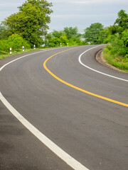 Fototapeta premium Beautiful country road with trees on both sides during the daytime.