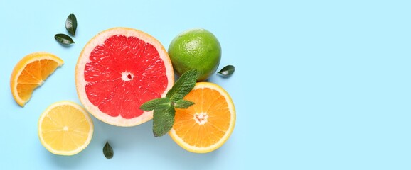 Many different citrus fruits on light blue background with space for text, top view