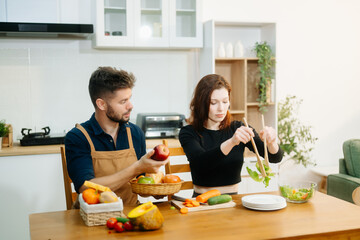 Couple cooking at home. young couple cooking together with Bread and fruit fresh vegetables, embracing healthy eating