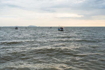 Naklejka premium Fishery boat in sea against sky at Bangsaen, Chonburi. Sunset in bangsan beach