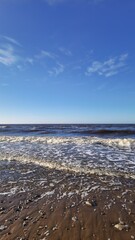 Blue Sky and Foamy Waves on Coastal Beach