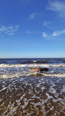 Serene Waves Rolling on Sandy Beach Under Blue Sky