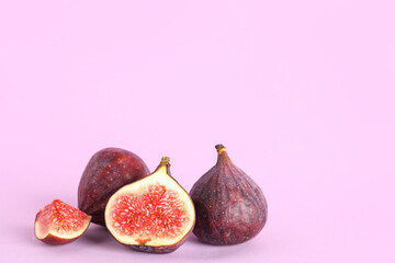 Fresh juicy cut figs on lilac background