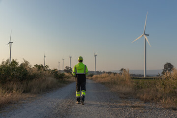 Obraz premium Survey Team Alternative energy for future. Engineers survey and checking wind turbines in sunset. Wind Turbine Renewable energy technology and sustainability.