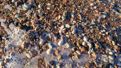 Seaside Rocks and Pebbles Washed by Ocean Foam