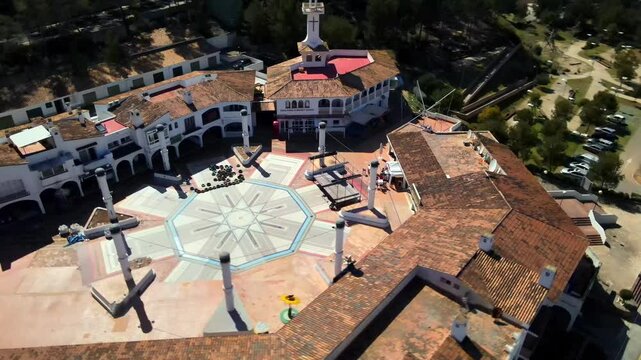Discover the beautiful architecture and vibrant atmosphere of Santa Ponsa in Mallorca. The square features unique columns and a mix of locals and tourists enjoying the area.