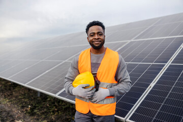 Portrait of black migrant worker in uniform at solar farm.