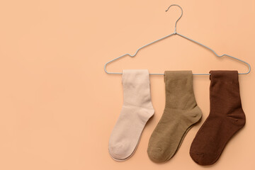 Hanger with basic color socks on beige background