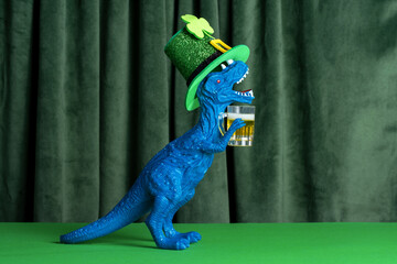 Funny dinosaur in green hat with beer  celebrating St. Patrick's day.