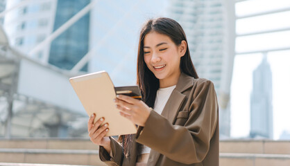 Happy smile young woman using credit card and digital tablet for shopping online payment