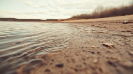 Calm lake water lapping gently on sandy shore.