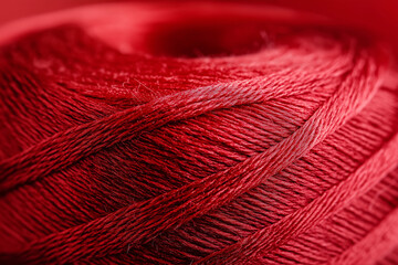 Bold Crimson Thread Tightly Coiled with Pure White Background, Representing Artistic Crafting Precision