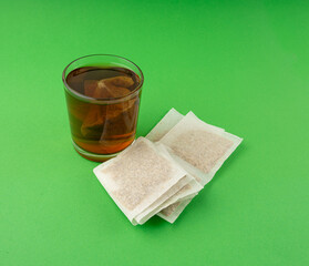 Herbal tea sachet in glass, hot water with chamomile and Hypericum or St. John's wort teabag