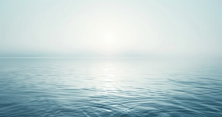Obraz premium A serene seascape with a soft, hazy horizon and gentle water reflections.