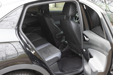Rear leather passenger seats in modern lux electric car. Leather car passenger seat. Control unit with electric seat adjustment media system for rear passengers in luxury car. Car interior detail