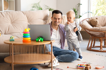Father showing something to his child on laptop at home