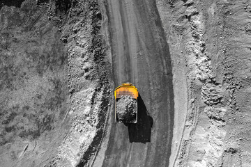 Big yellow quarry dump truck moving on open pit mine, Industry mining production, top view