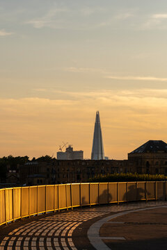 A breathtaking view during golden hour featuring London's iconic skyscraper, the Shard, juxtaposed against a warm, soft sky that evokes feelings of serenity and wonder in London