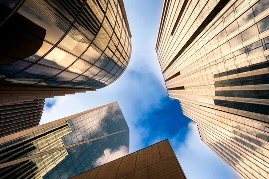 This dynamic shot showcases towering glass buildings reaching for the sky, framed by vibrant clouds, creating a sense of aspiration and modernity in urban landscapes in London